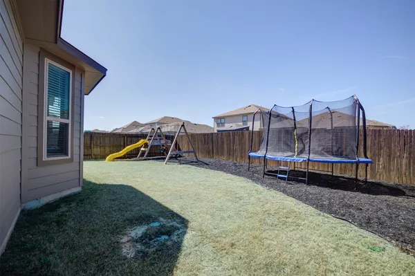 a backyard of a house with barbeque oven and a yard