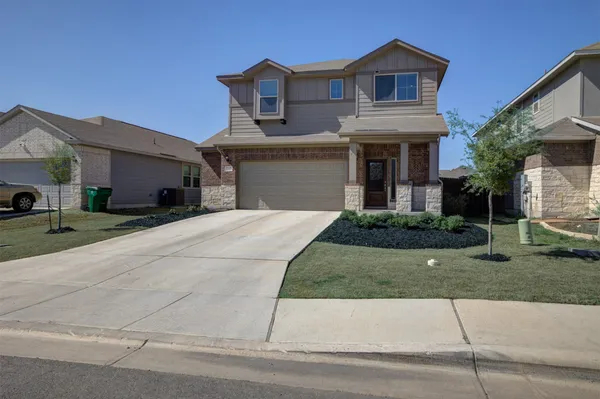 a front view of a house with a yard and garage