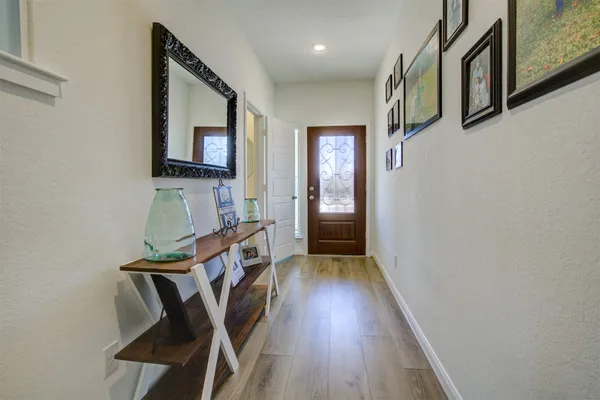 a view of a hallway with wooden floor and staircase