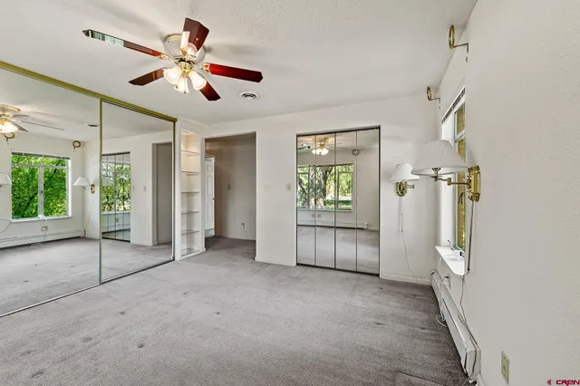 a view of a livingroom with a ceiling fan and window