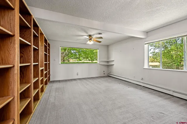 a spacious bedroom with a large bed couch and a large window