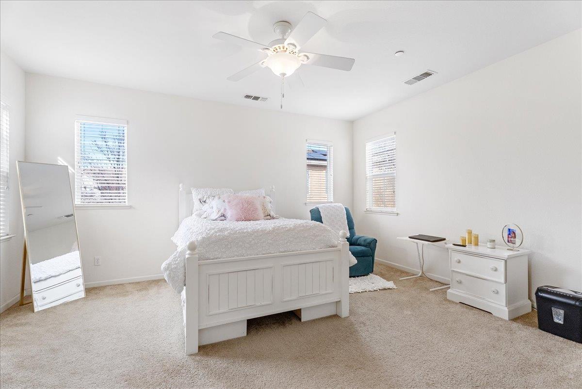 719 Courtyards Loop Lincoln, CA 95648 - Photo 17 of 33 a bedroom with a bed and a chandelier