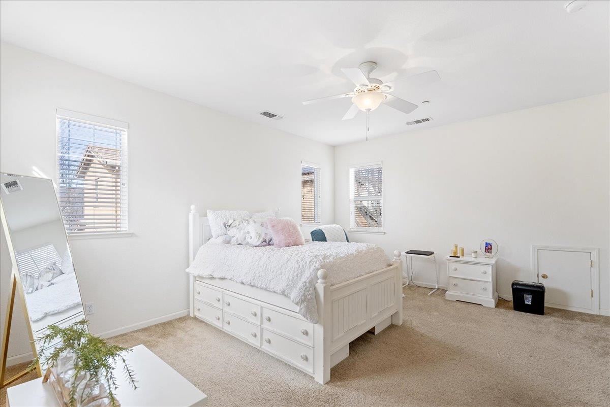719 Courtyards Loop Lincoln, CA 95648 - Photo 24 of 33 a bedroom with bed and a chandelier