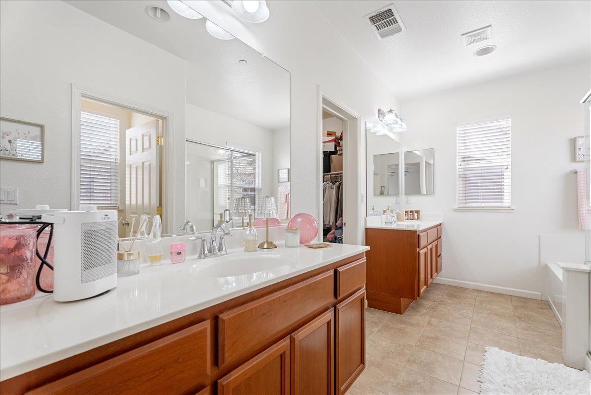 719 Courtyards Loop Lincoln, CA 95648 - Photo 25 of 33 a bathroom with double vanity sinks a mirror and a shower