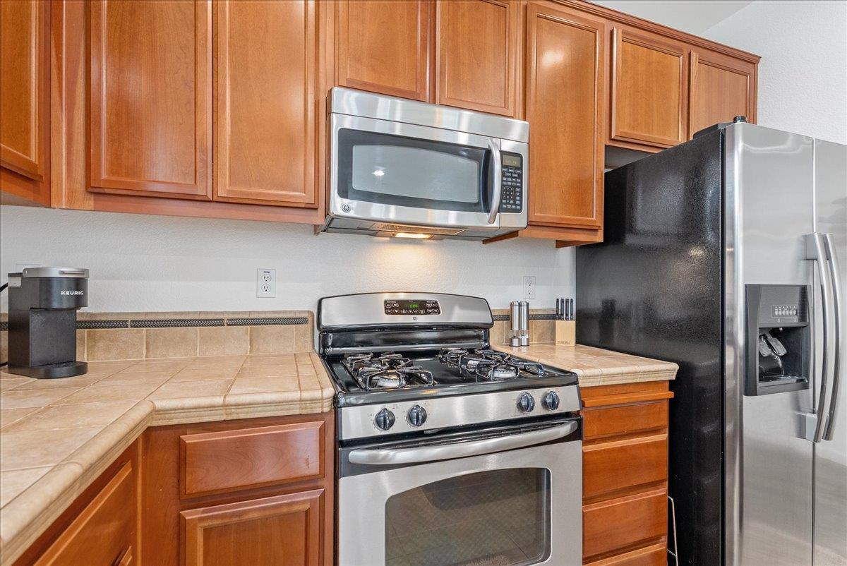 719 Courtyards Loop Lincoln, CA 95648 - Photo 10 of 33 a kitchen with stainless steel appliances granite countertop a refrigerator stove and microwave