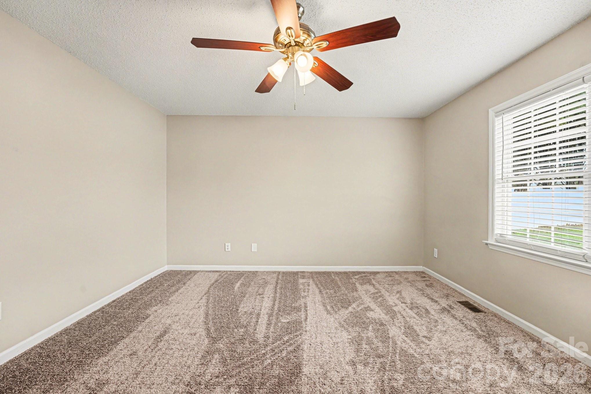 134 Clearview Road Statesville, NC 28625 - Photo 14 of 16 an empty room with a window and a ceiling fan