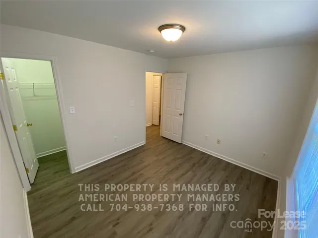 an empty room with wooden floor and entrance