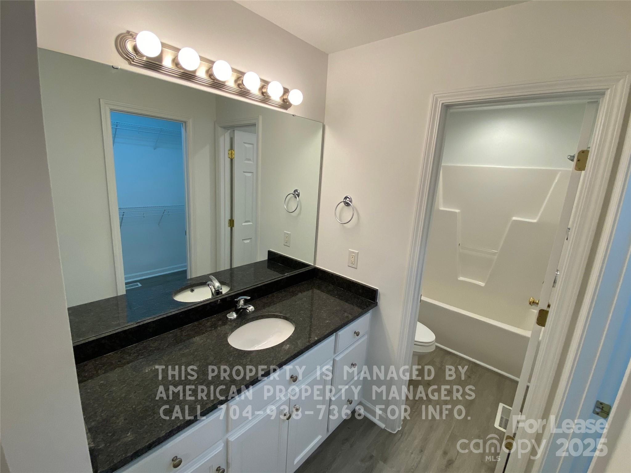 41 Ridge Court Southeast Concord, NC 28025 - Photo 7 of 14 a bathroom with a granite countertop sink a mirror and a shower