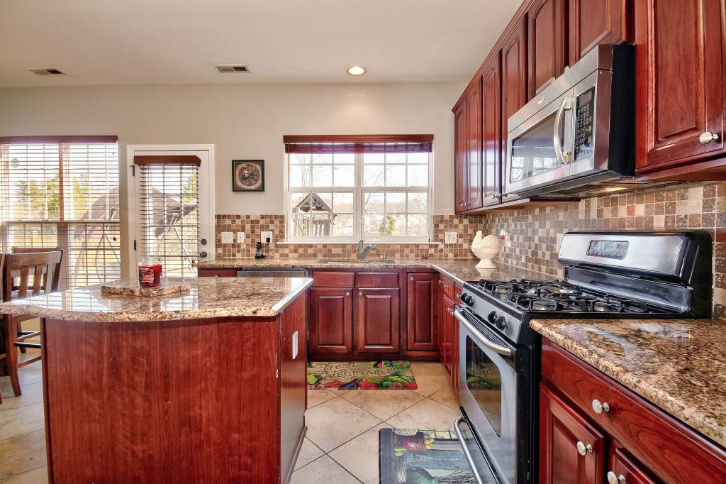 7754 San Gabriel Street Raleigh, NC 27613 - Photo 9 of 25 Spacious kitchen includes an island with granite, stunning cabinets, ss appliances, tile back splash, pantry, gas stove! What more can I say? Fabulous kitchen? Kitchen