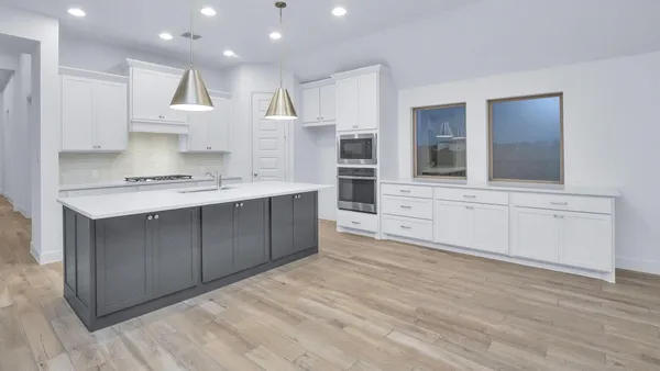 a large white kitchen with a sink stainless steel appliances and cabinets