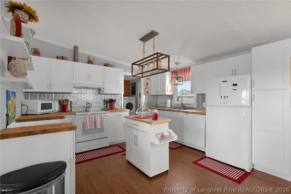 a kitchen with cabinets a sink and white appliances