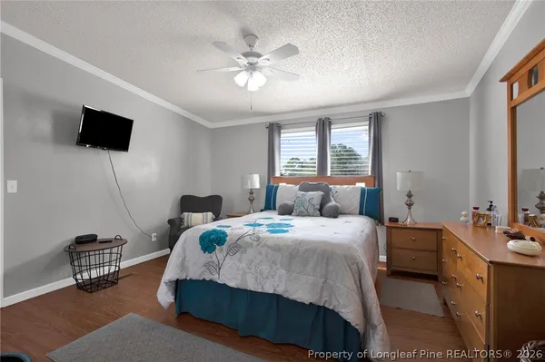 a bedroom with a bed a chandelier and a flat screen television