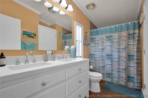 a bathroom with a double vanity sink toilet and shower