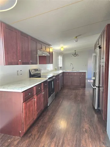 a kitchen with stainless steel appliances granite countertop a sink refrigerator and cabinets