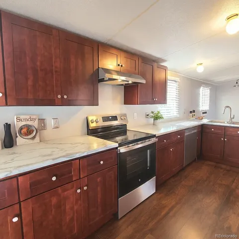a kitchen with a sink a stove and cabinets