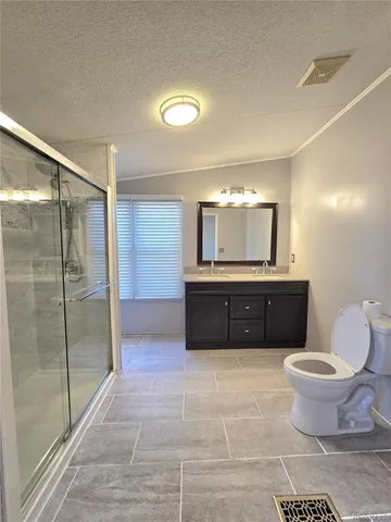 a bathroom with a granite countertop sink toilet and shower
