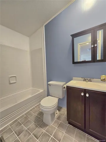 a bathroom with a granite countertop toilet a sink and a bathtub