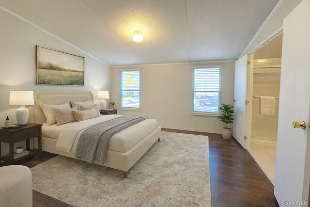 a spacious bedroom with a bed and a painting on the wall