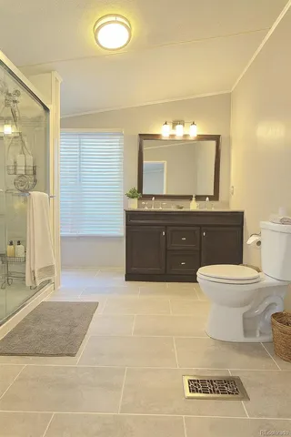 a spacious bathroom with a toilet sink and mirror