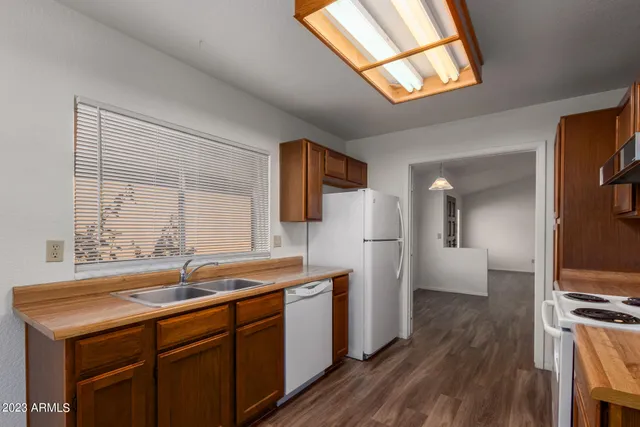 a kitchen with a sink cabinets stainless steel appliances and a large window