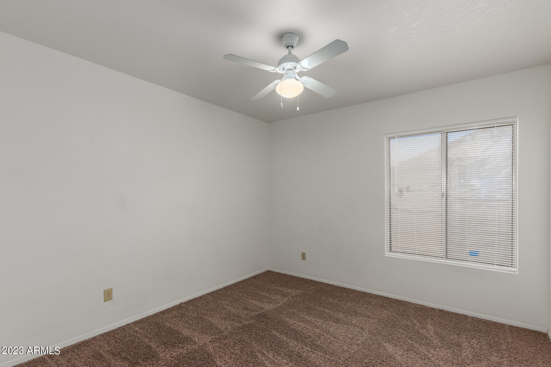 7331 West Paradise Drive Peoria, AZ 85345 - Photo 20 of 27 an empty room with chandelier fan and windows