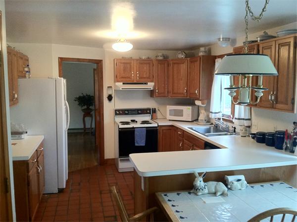 236 Gardiner Road Milton, MA 02169 - Photo 3 of 12 a kitchen with stainless steel appliances granite countertop a refrigerator a sink dishwasher a stove a dining table and chairs with wooden floor