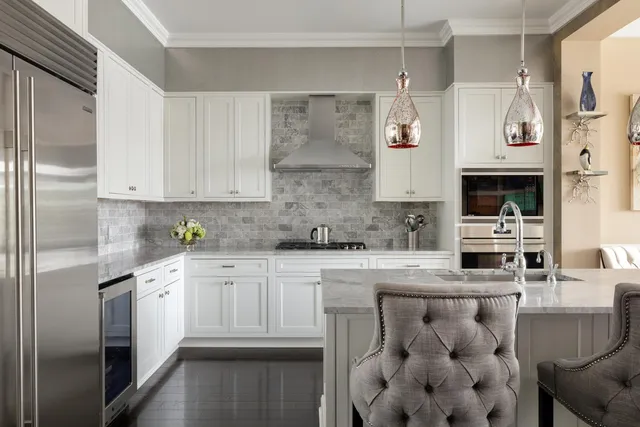 a kitchen with stainless steel appliances granite countertop a refrigerator sink stove and white cabinets