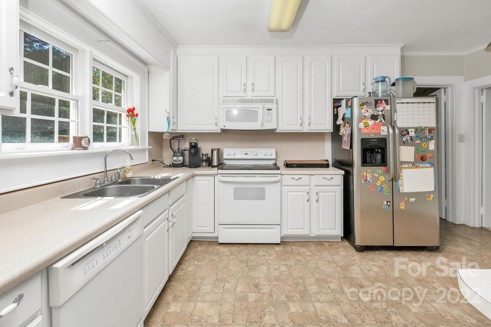 581 Flynn Road Rutherfordton, NC 28139 - Photo 30 of 37 a kitchen with white cabinets and white appliances