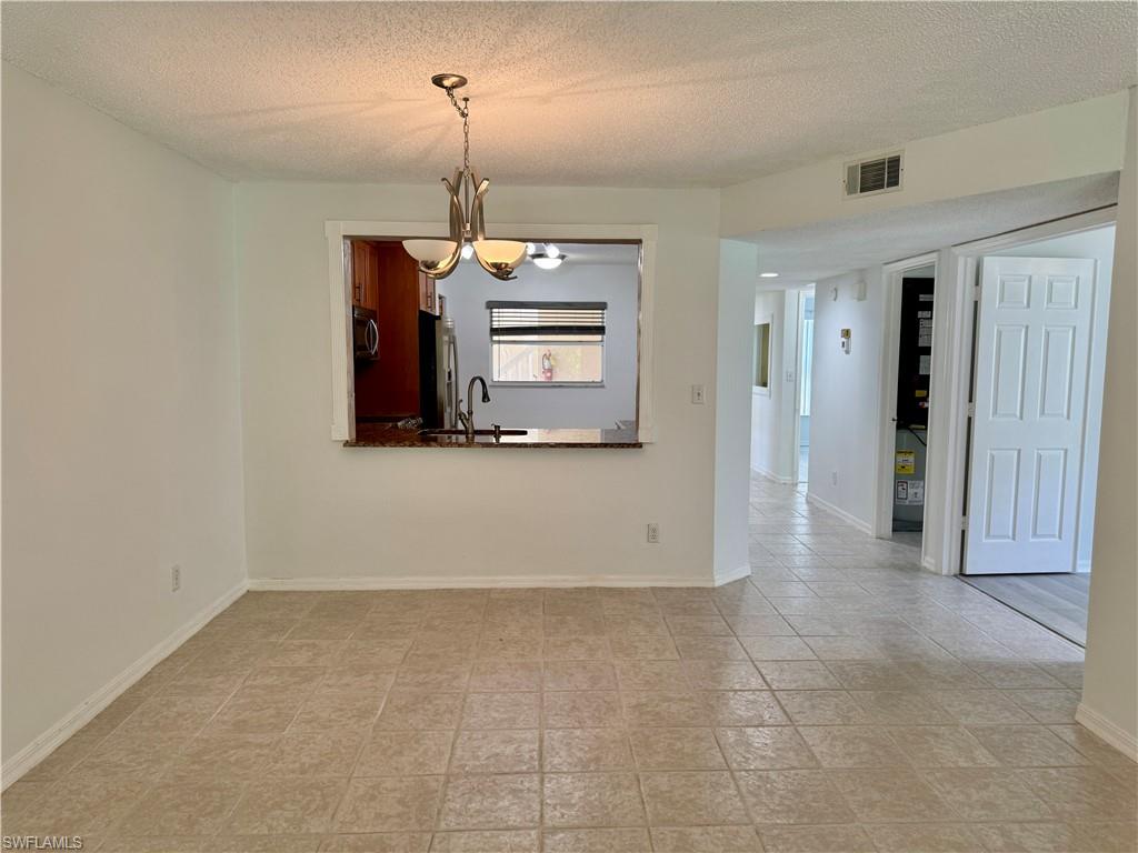 661 Squire Circle, Unit 101 Naples, FL 34104 - Photo 15 of 25 a view of a hallway with a chandelier