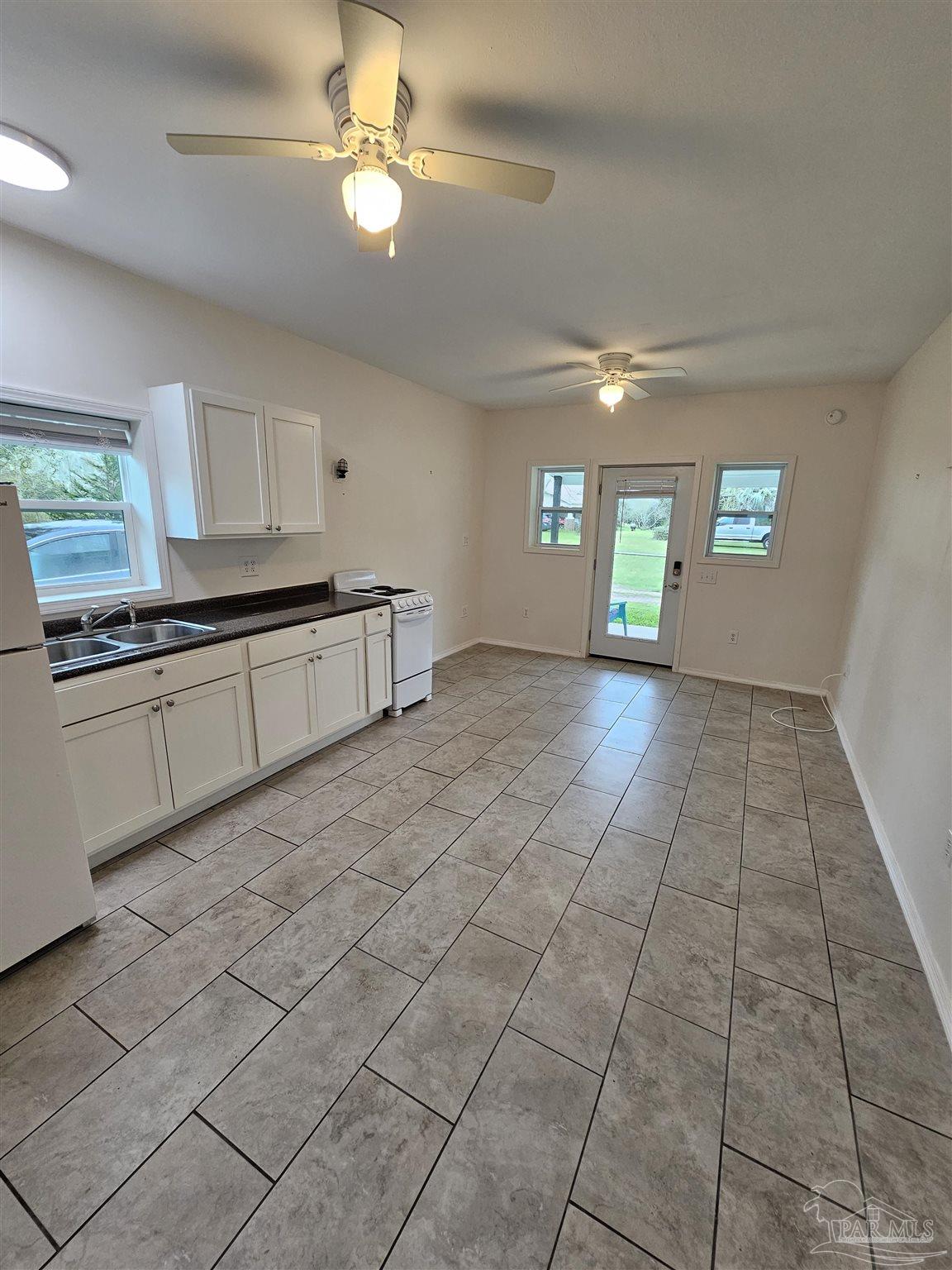 9775 North Loop Road, Unit 1 Pensacola, FL 32507 - Photo 2 of 12 a large kitchen with cabinets and a stove top oven