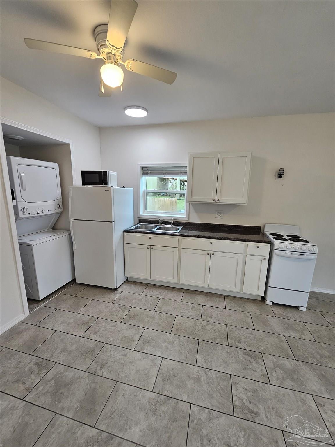 9775 North Loop Road, Unit 1 Pensacola, FL 32507 - Photo 4 of 12 a kitchen with a cabinets a sink and a stove top oven