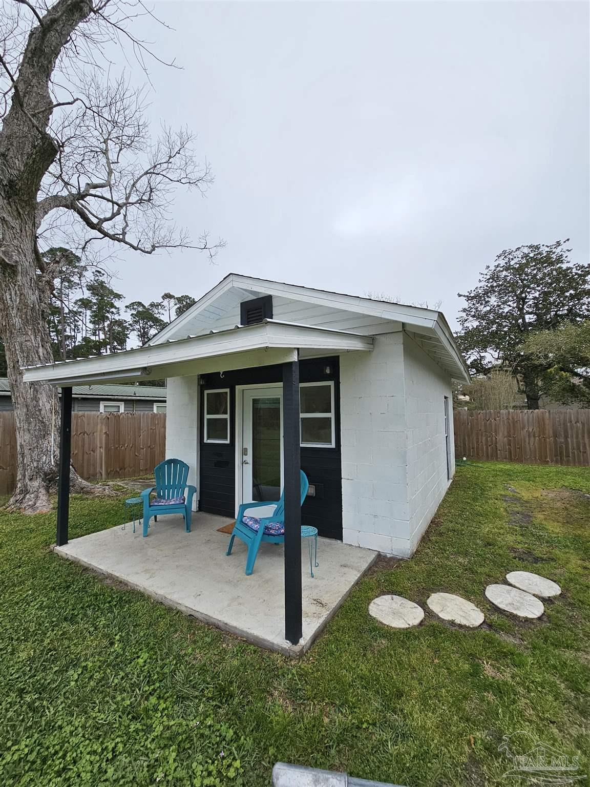 9775 North Loop Road, Unit 1 Pensacola, FL 32507 - Photo 5 of 12 a view of a house with backyard porch and sitting area