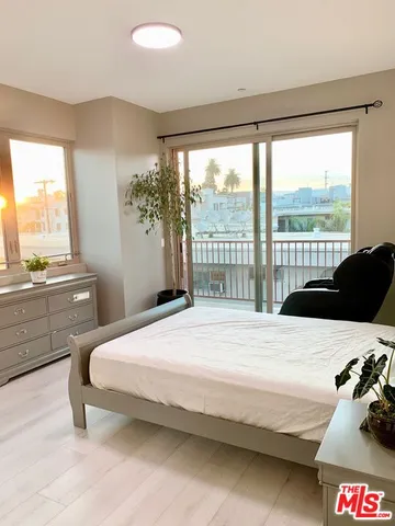 a bedroom with a bed and a large window