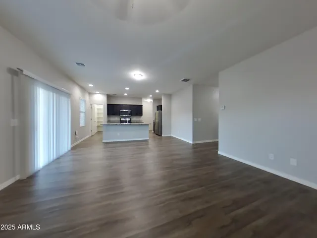 a view of kitchen with a refrigerator a stove top oven and a kitchen counter top