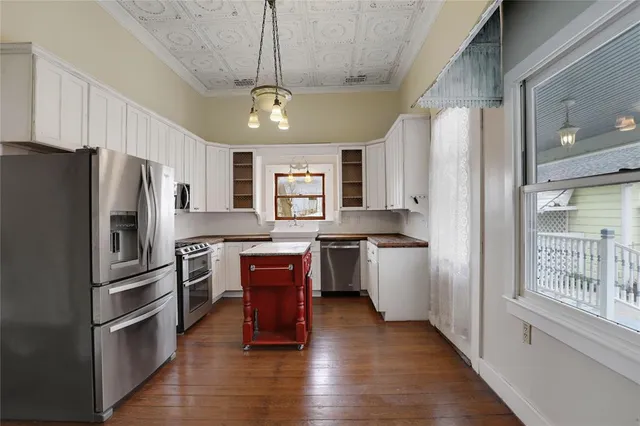 a kitchen with stainless steel appliances wooden floor sink and refrigerator
