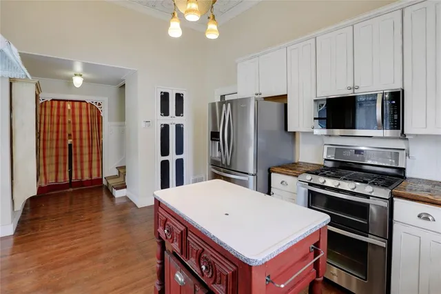a kitchen that has a kitchen island wooden cabinets and stainless steel appliances