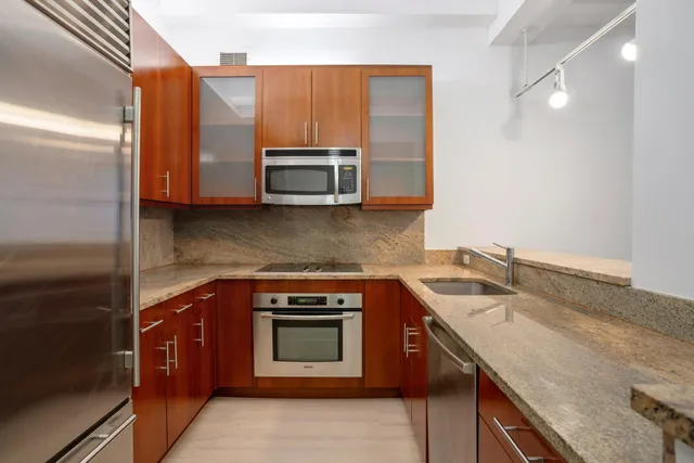 a kitchen with stainless steel appliances granite countertop a sink stove and microwave