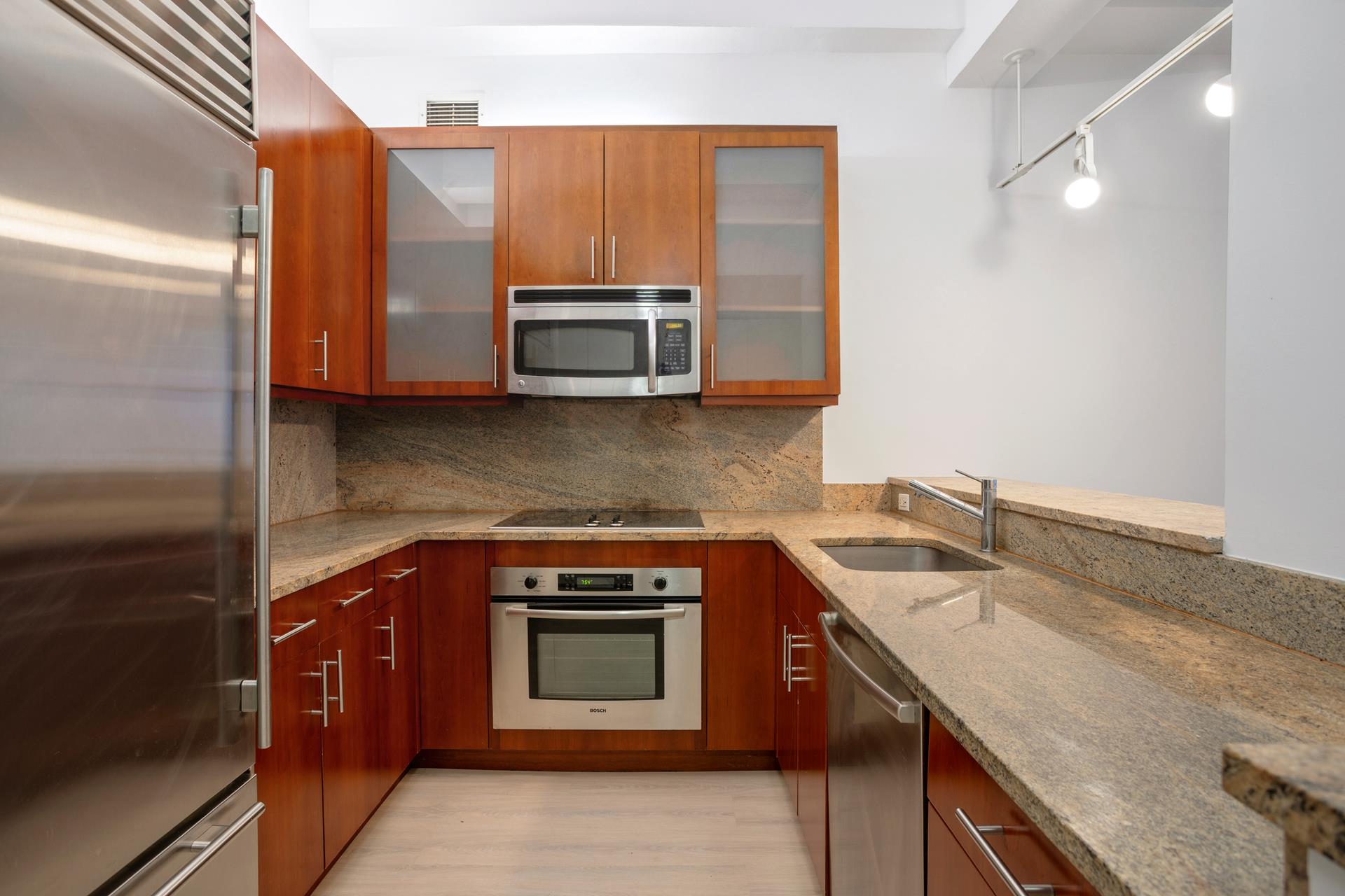 a kitchen with stainless steel appliances granite countertop a sink stove and microwave