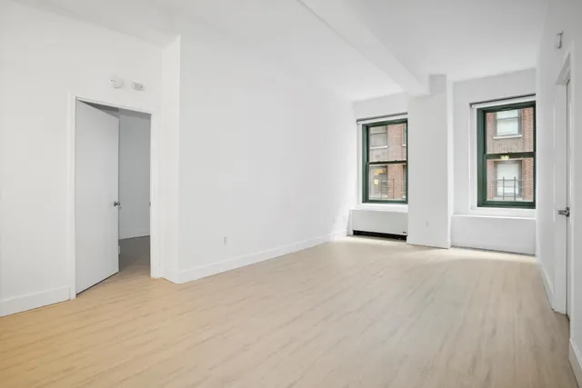 an empty room with windows and closet