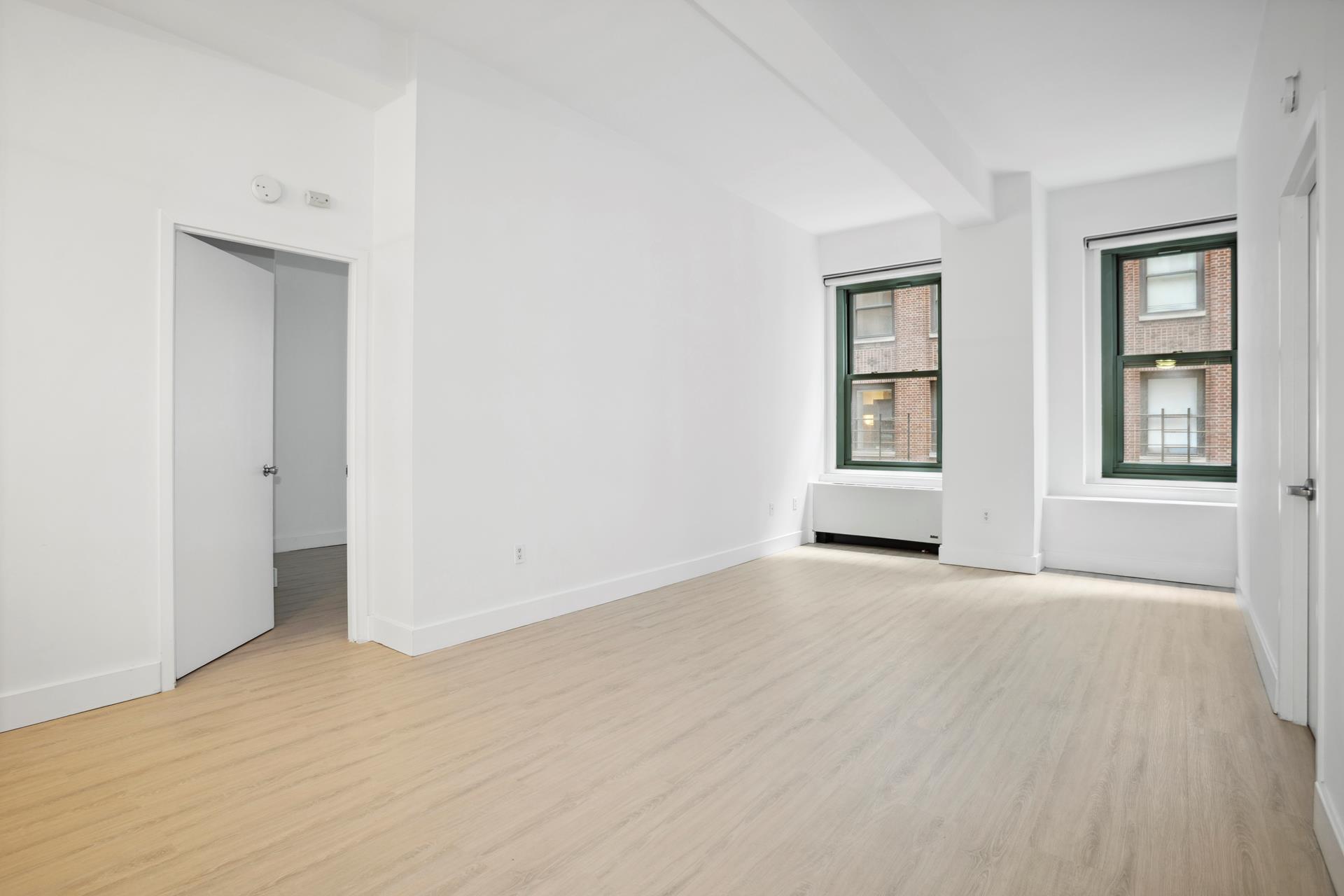 80 John Street, Unit 7G Manhattan, NY 10038 - Photo 3 of 9 an empty room with windows and closet