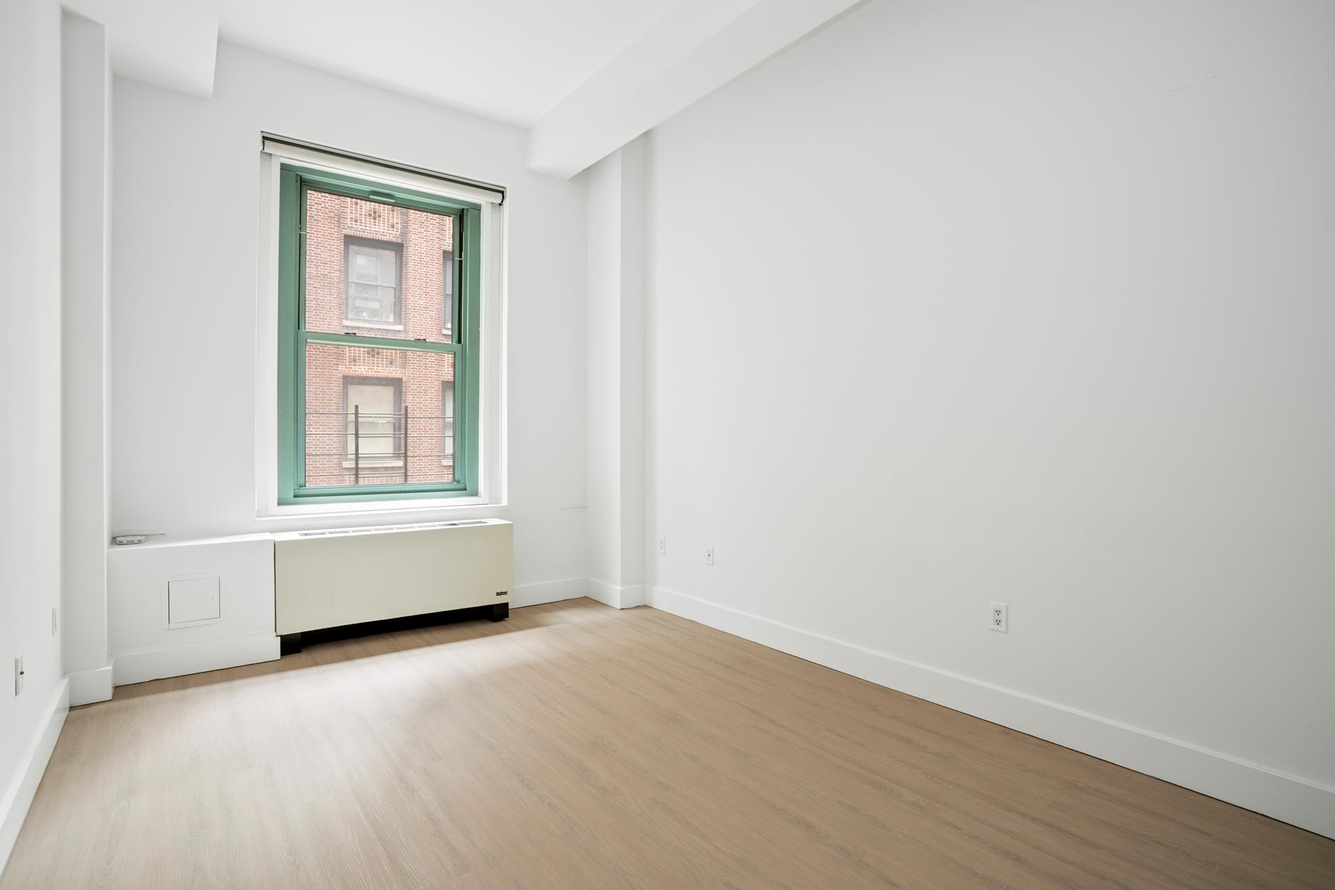 80 John Street, Unit 7G Manhattan, NY 10038 - Photo 7 of 9 an empty room with wooden floor and windows