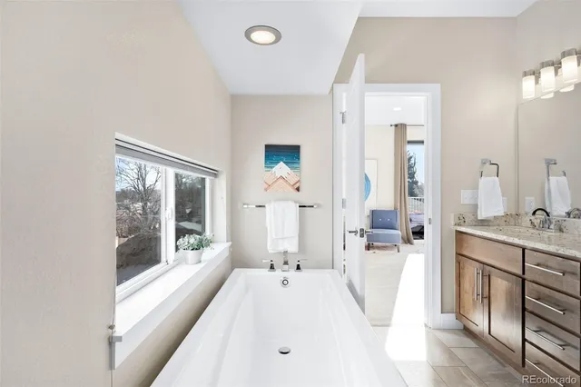 a large white room with a large window and stainless steel appliances