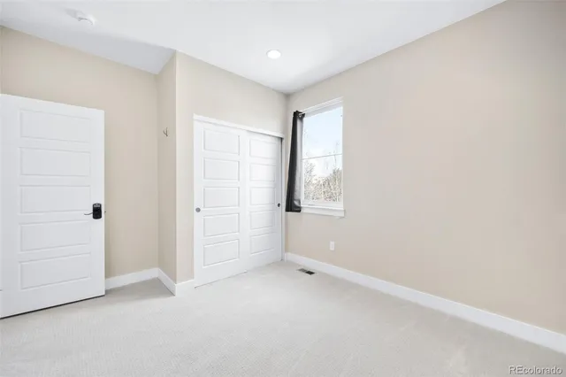 an empty room with windows and closet