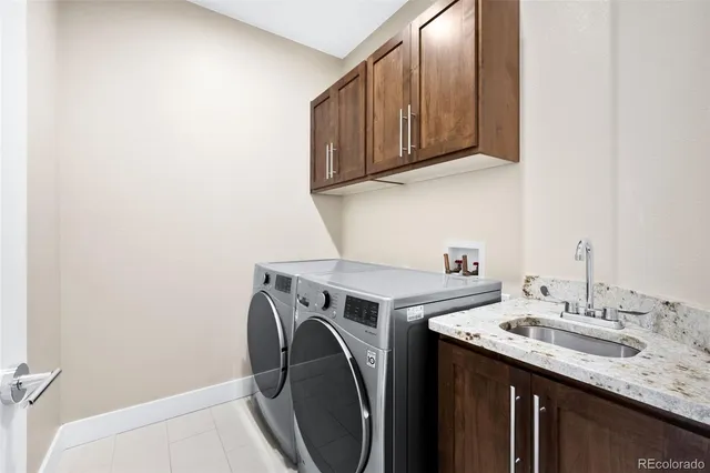 a utility room with sink dryer and washer