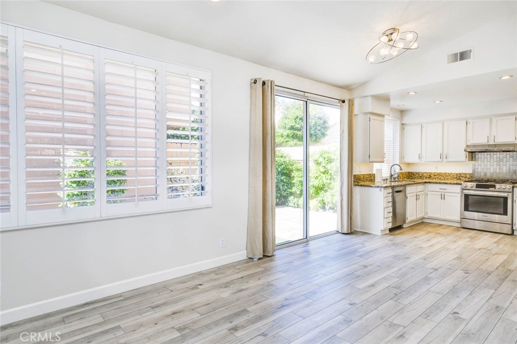 1 La Ronda Irvine, CA 92606 - Photo 10 of 29 a kitchen with wooden floors and white cabinets