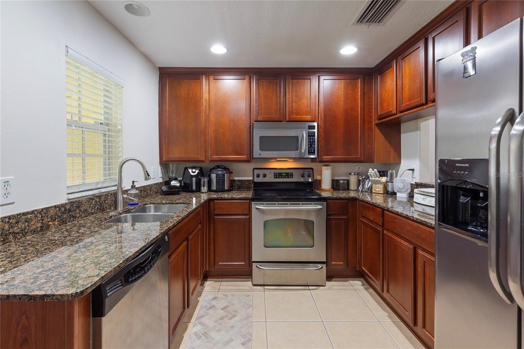 10901 Brickside Court Riverview, FL 33579 - Photo 11 of 36 a kitchen with stainless steel appliances granite countertop a sink stove and refrigerator