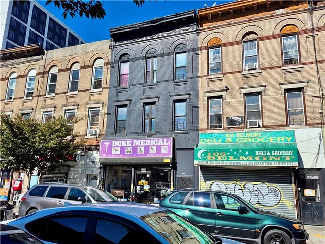 a view of a cafe with a couple of cars parked in front of a building
