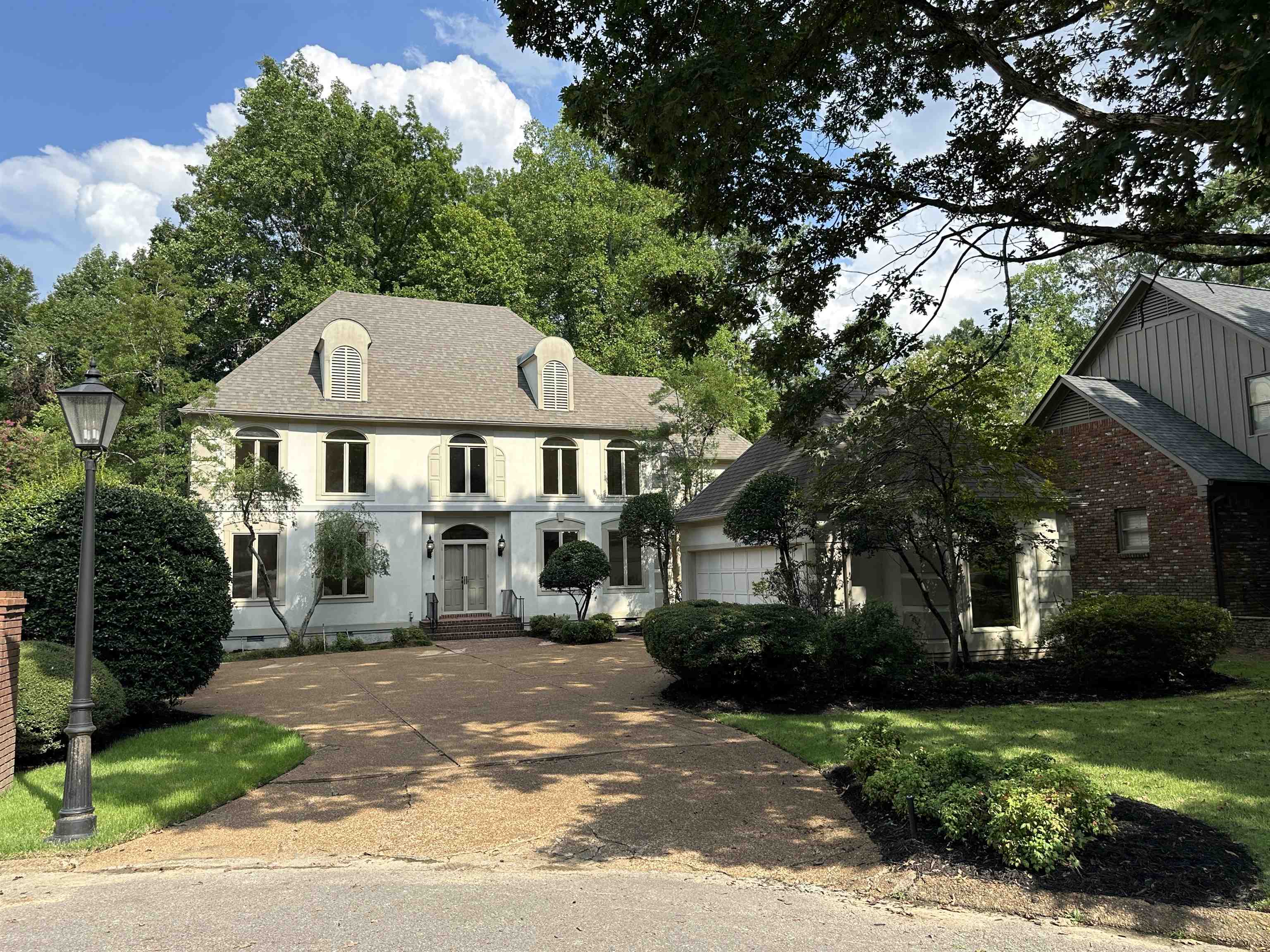 a front view of a house with yard and green space