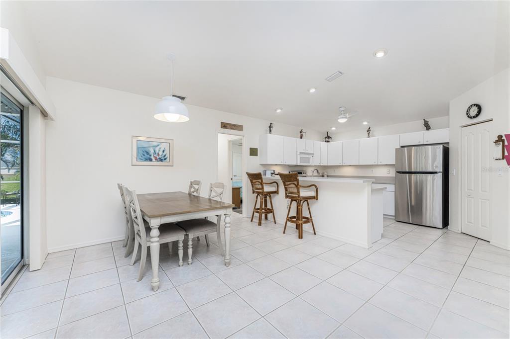 443 Rotonda Circle Rotonda West, FL 33947 - Photo 15 of 59 a view of kitchen with refrigerator microwave and dining table