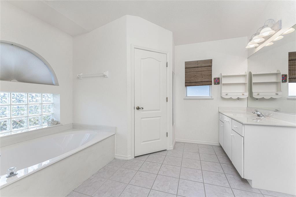443 Rotonda Circle Rotonda West, FL 33947 - Photo 25 of 59 a spacious bathroom with a bathtub sink and mirror
